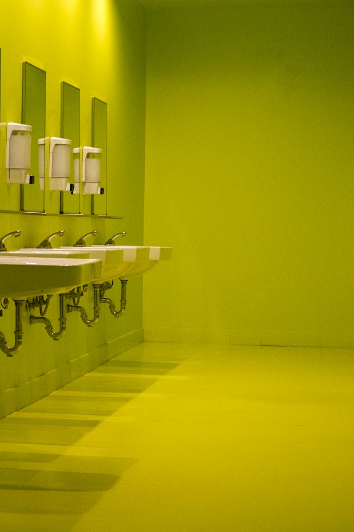 Modern green bathroom interior with multiple sinks and mirrors. Sleek, vibrant, and contemporary design.
